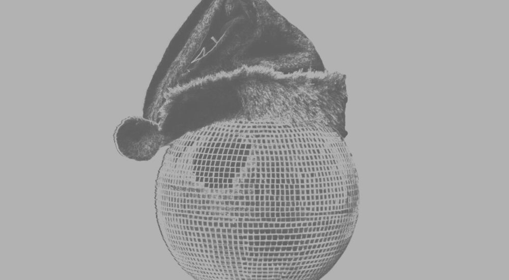 Image en noir et blanc montrant une boule disco coiffée d'un chapeau de père Noël